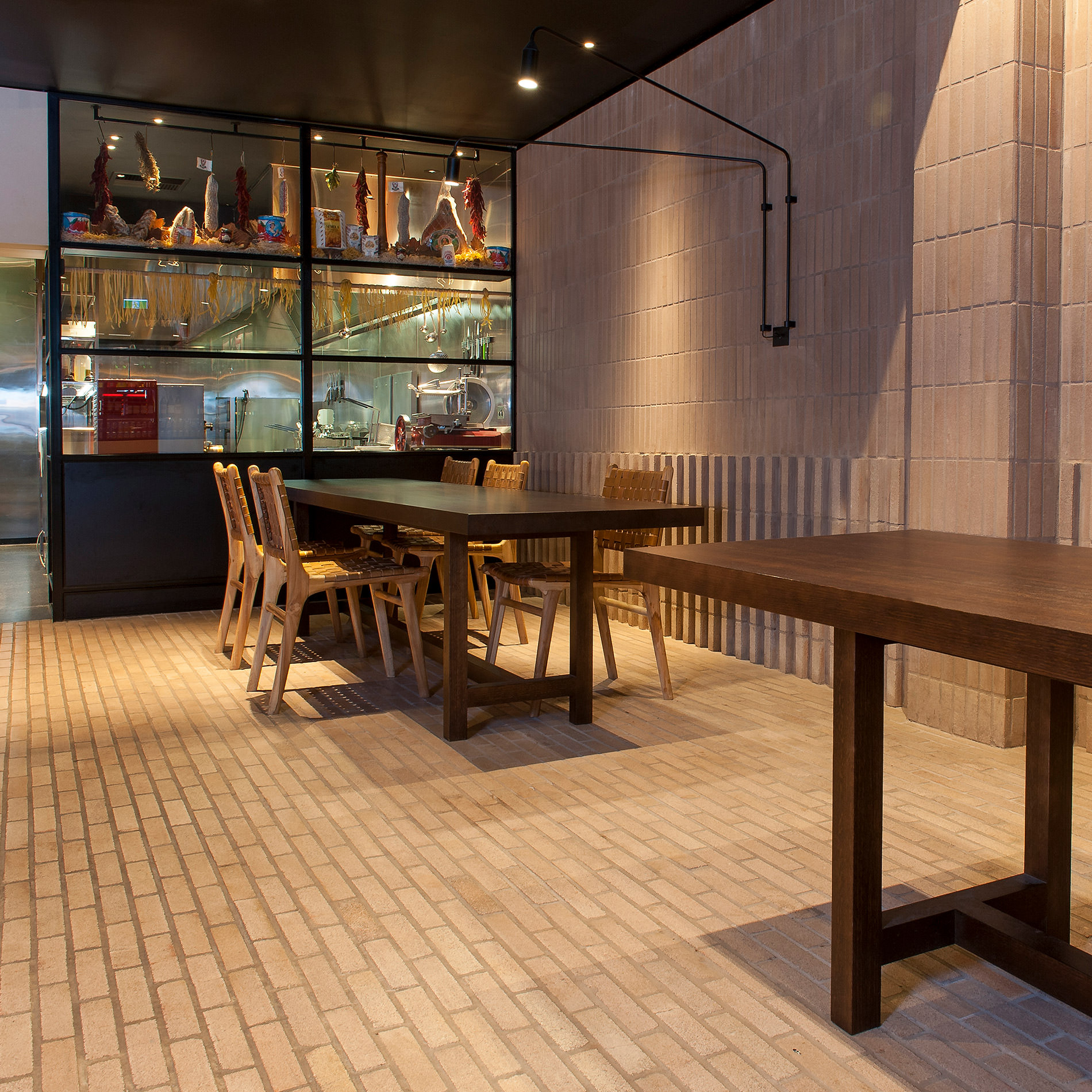 The very back wall showcases a delight of cured meats to feast on as you sit at the solid oak designer furniture tables by Australian designer FrancoCrea