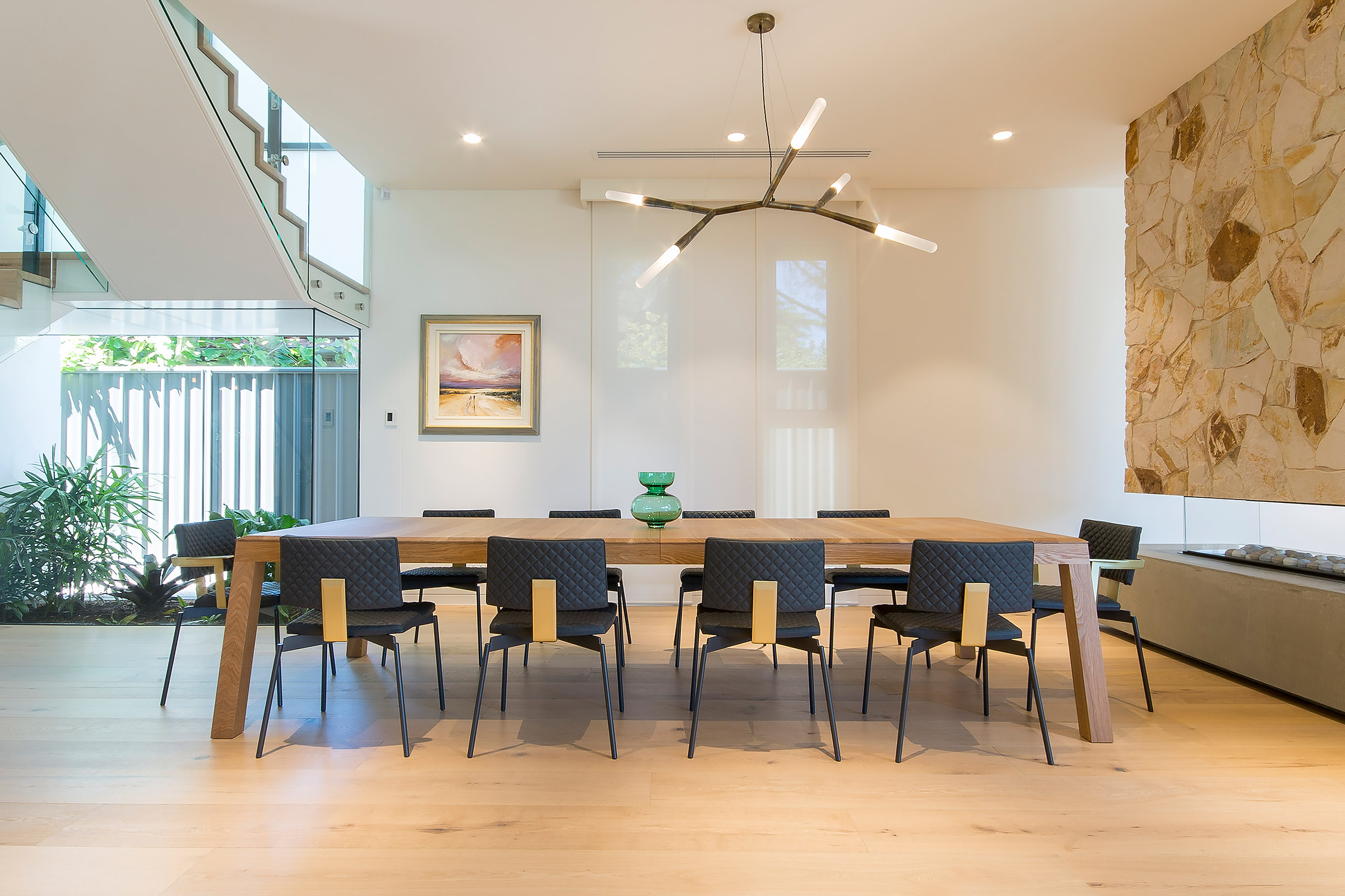 soft natural light filters down over the designer dining table and chairs created by Australian designer FrancoCrea in this inviting dining room