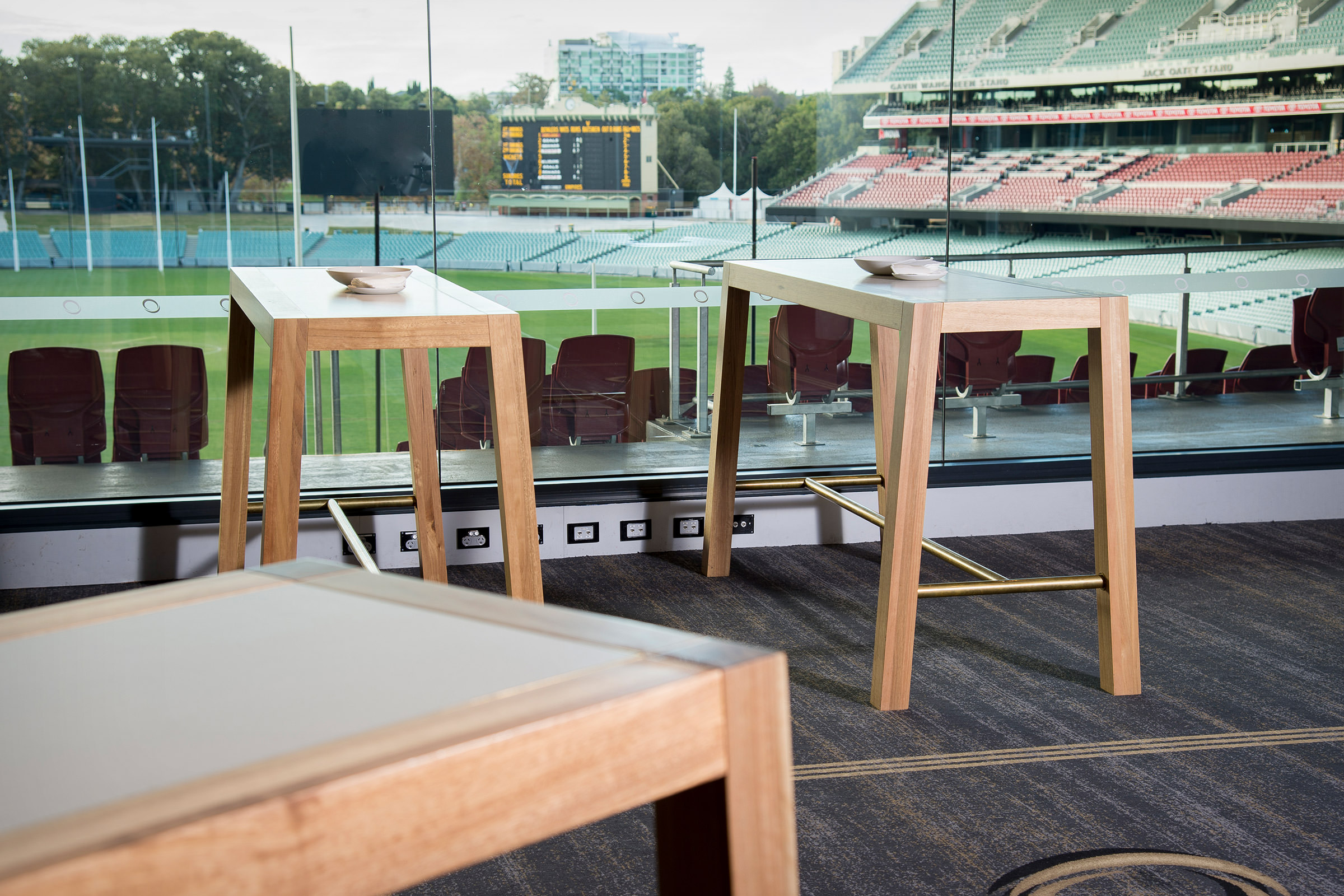 The iconic Adelaide Oval can be glimpsed through the floor to ceiling glass windows here that Australian designer FrancoCrea's bespoke tables rest against