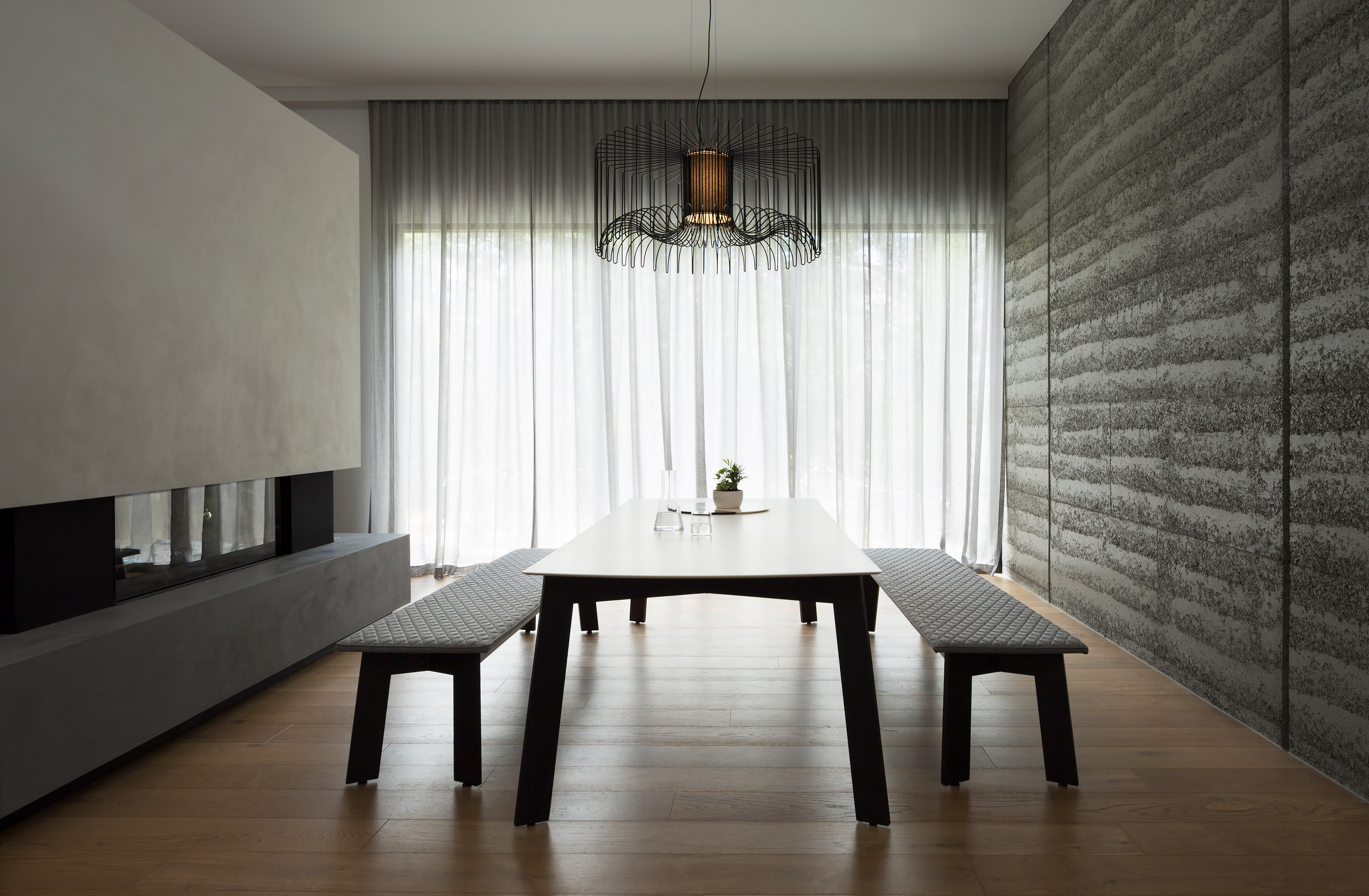 The soft linen curtains allow dappled light to filter through into this stunning dining room onto Australian designer FrancoCrea's minimalist dining table and bench seats.