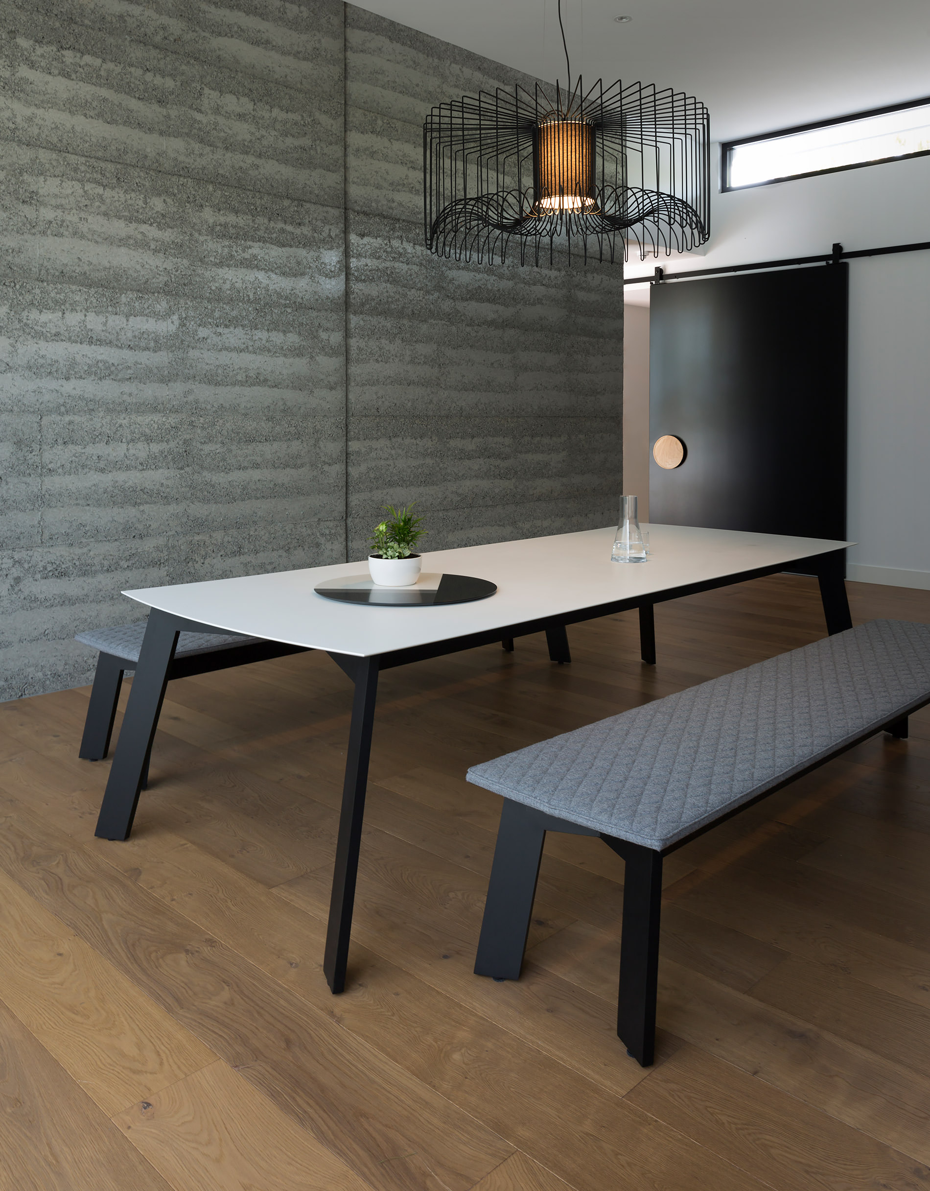 At first glance everthing works seamlessly in this family dining room from the rammed earth walls to the minimalist designer dining table and benches by Australian designer FrancoCrea