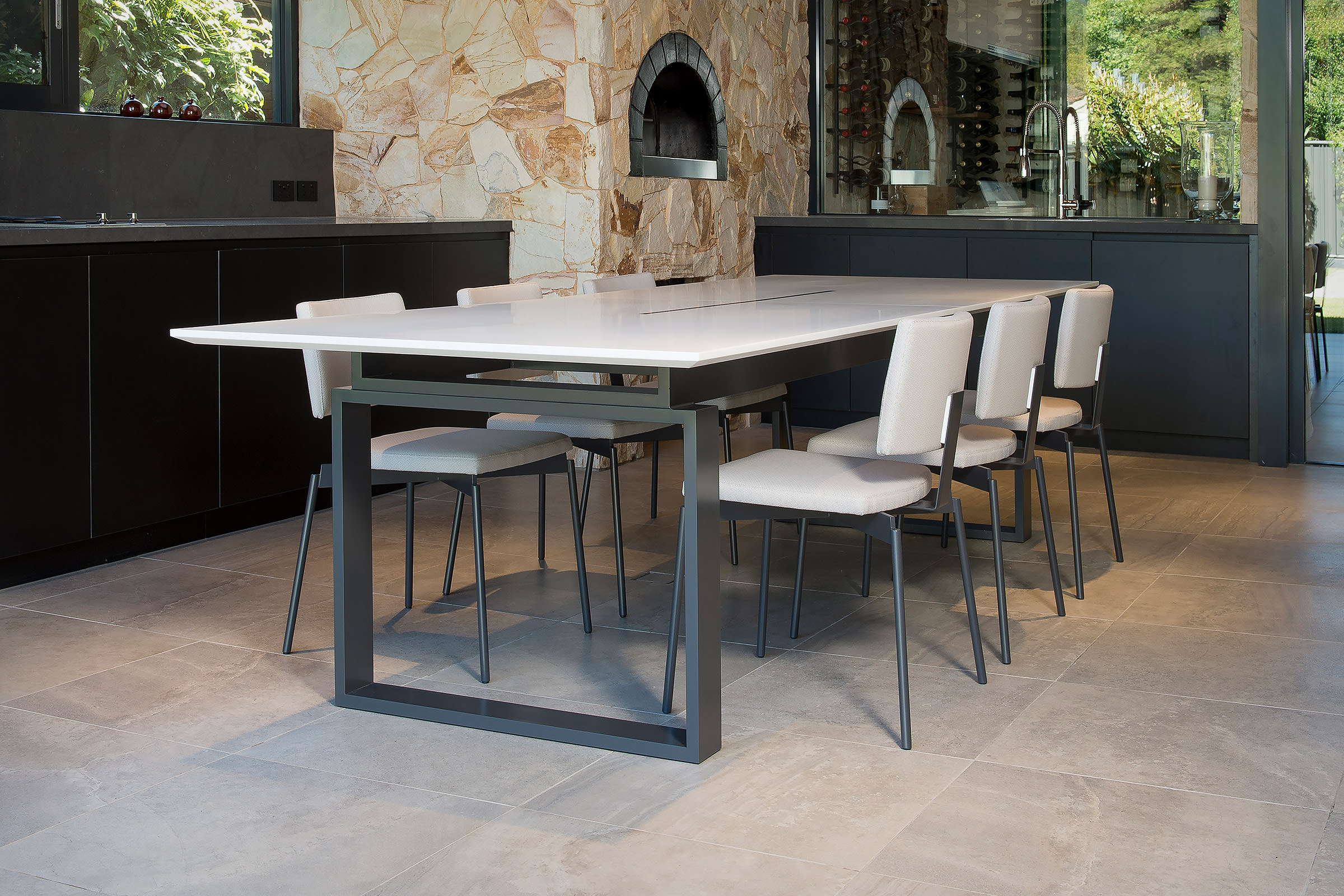 a glimpse of the wood fired oven surrounded by natural sand stone in the background invites you sit at the designer dining table created by Australian Designer FrancoCrea