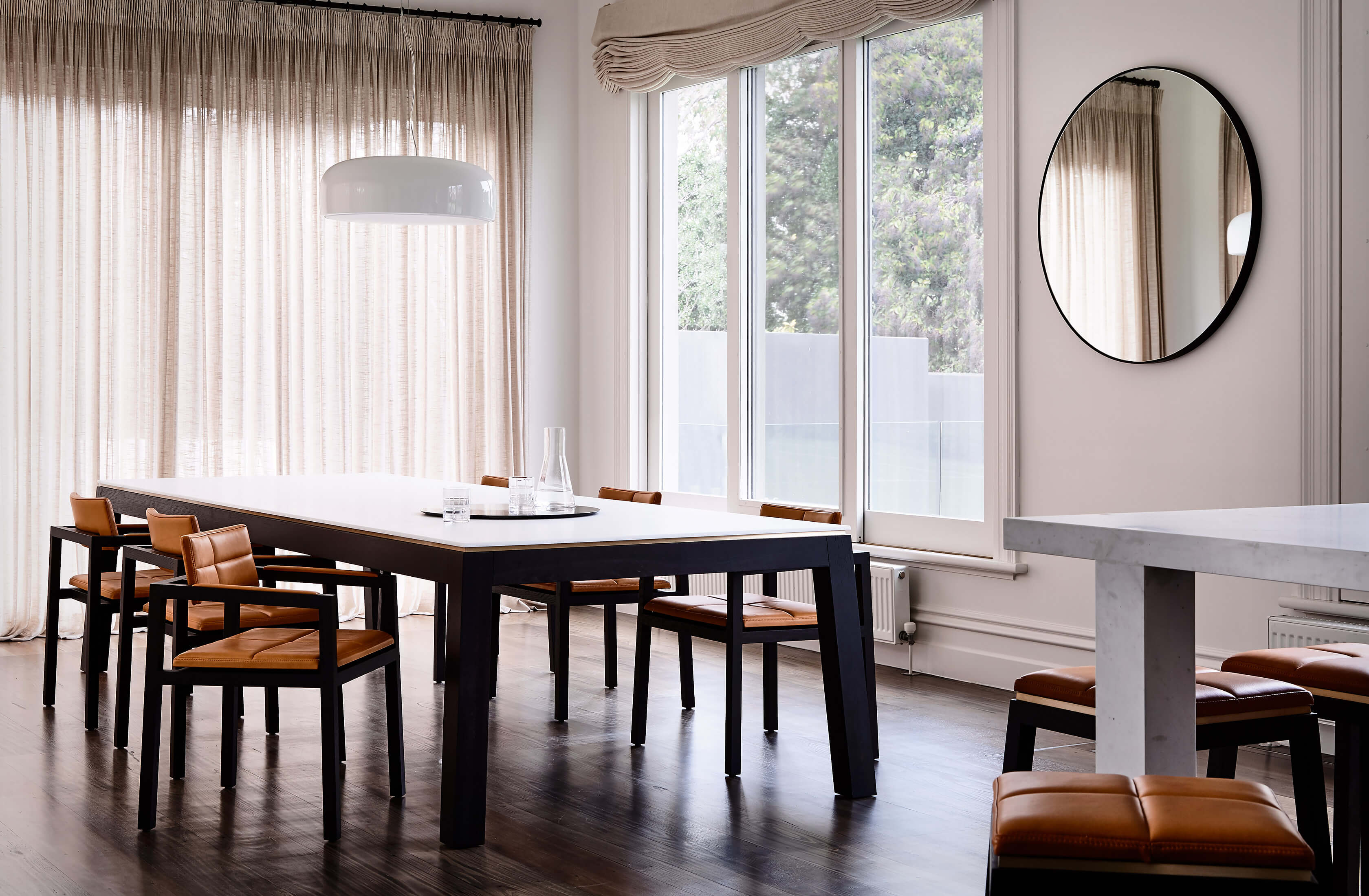 Soft linen curtains anchor the background of this refined luxury home with Australian designer FrancoCrea's designer dining table and chairs stealing the show