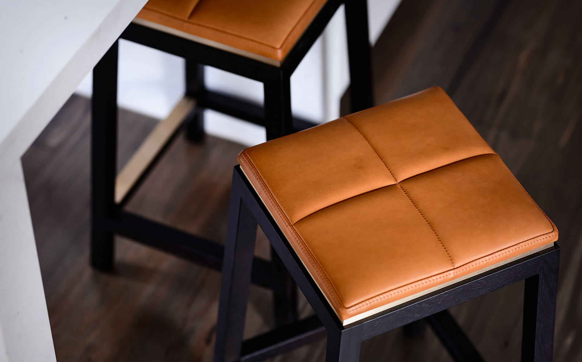The rich soft supple texture of the tan leather on these designer stool seat pad immediately speaks to you to touch and sit