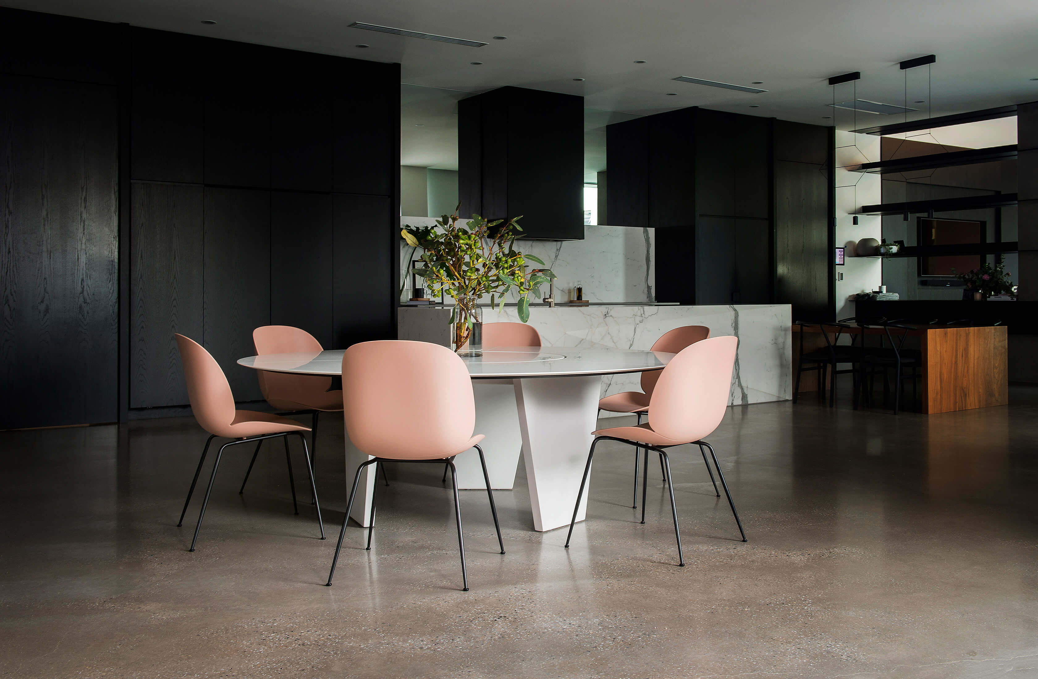 A moody kitchen backdrop sets the scene for the contrasting light white round designer dining table by Australian designer FrancoCrea to steal the show