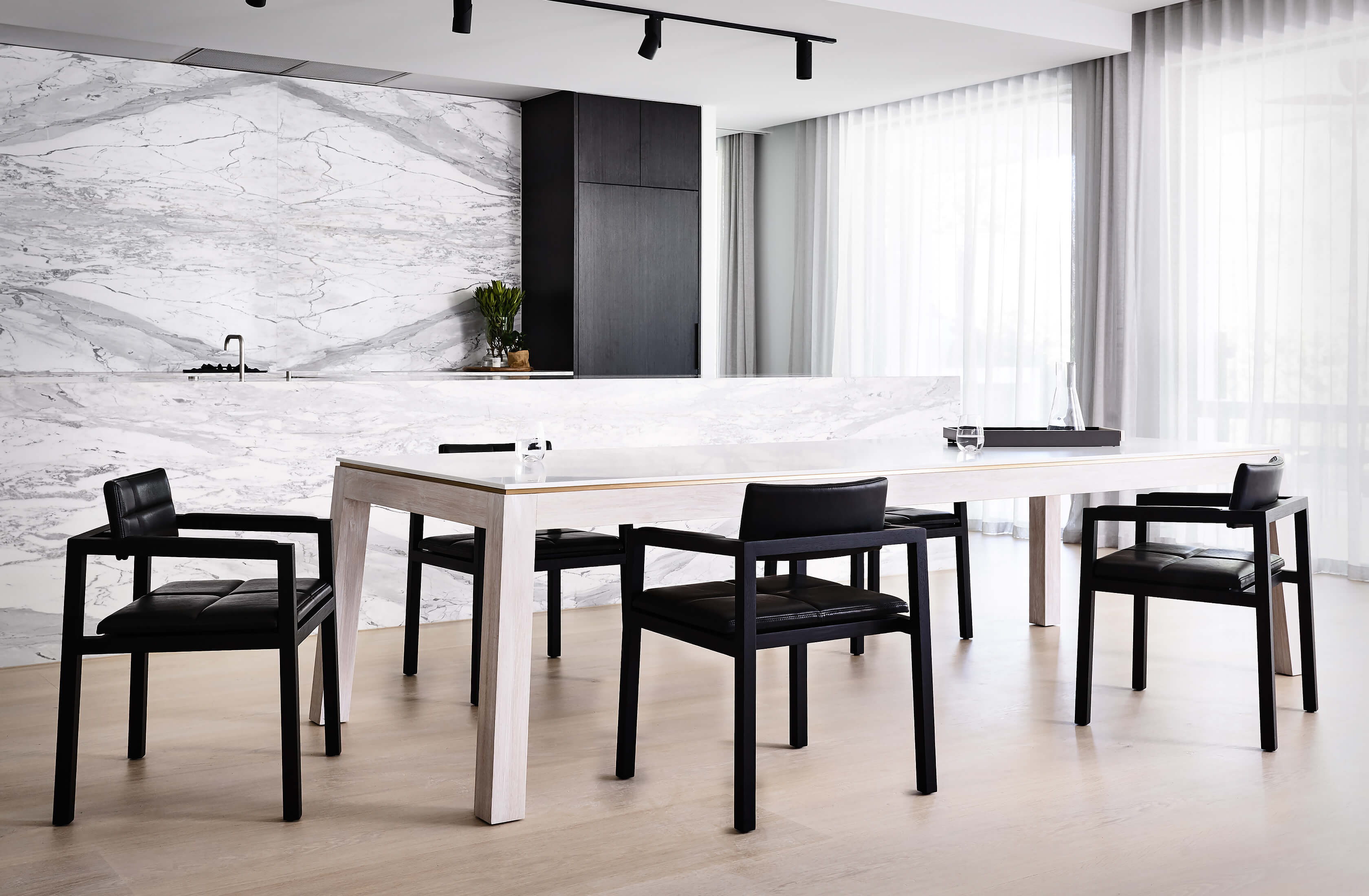 A sensational family home in Melbourne captures the natural light streaming in across the designer dining table by Australian designer FrancoCrea