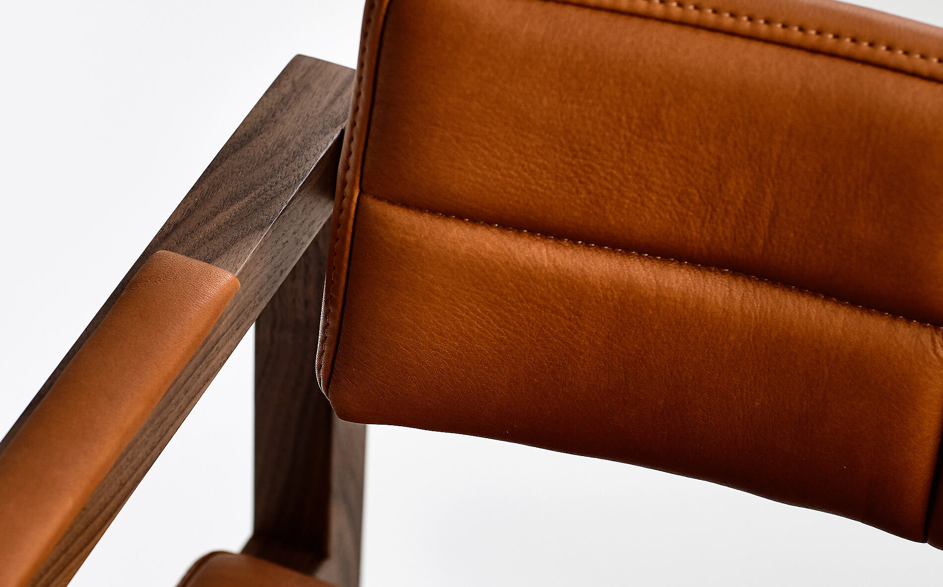 A dream dining room filled with designer dining chairs in walnut wood and buttery tan leather