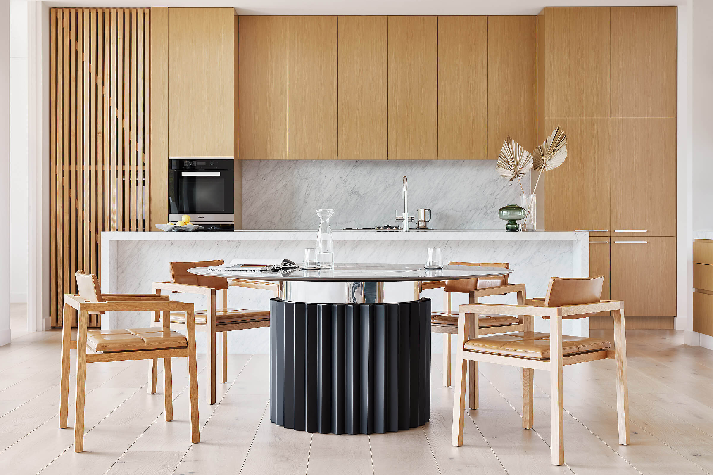 Four solid oak wood chairs gathered around FrancoCrea's designer dining table crafted with corian table top and mirror polished stainless steel base